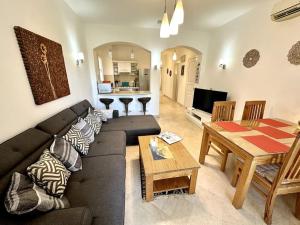 een woonkamer met een zwarte bank en een tafel bij 2 Bedroom Condo, with Pool, and Beach & Lagoon Access in Hurghada