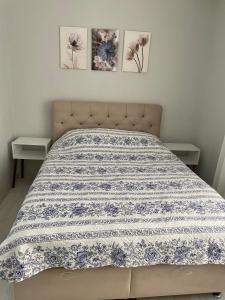 a bed with a blue and white blanket on it at Foça- Phokai Living. in Foça