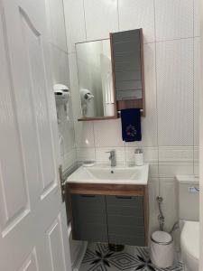 een badkamer met een wastafel, een toilet en een spiegel bij Foça- Phokai Living. in Foca