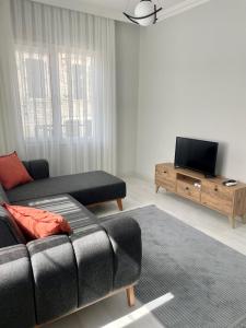 een woonkamer met een bank en een flatscreen-tv bij Foça- Phokai Living. in Foca