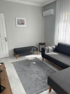 uma sala de estar com dois sofás pretos e um tapete em Foça- Phokai Living. em Foça