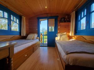 una camera con due letti in una casa di legno di Les Roulottes du Petit Gouffre de Padirac a Padirac