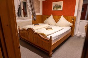 a bedroom with a wooden bed with two pillows on it at Pension Schrammsteinbaude in Bad Schandau