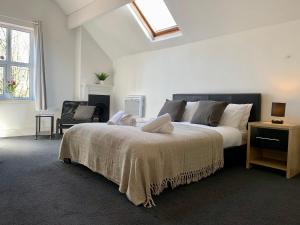 a bedroom with a large bed and a chair at Spacious 6BR Victorian Home in 14 Somerford Near Wolverhampton Centre with Free Parking in Willenhall