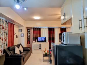 uma sala de estar com um sofá e uma televisão em Condo Airport NAIA Terminal-3 One Palm Tree Villas em Manila