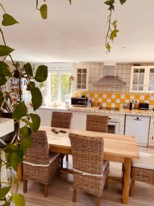 a kitchen with a wooden table and wicker chairs at Etape du soleil in Lunel