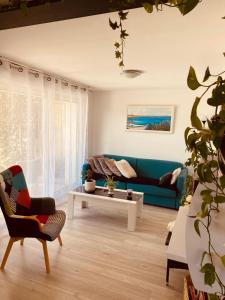 uma sala de estar com um sofá azul e uma mesa em Etape du soleil em Lunel
