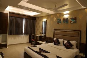 een hotelkamer met 2 bedden en een plafond bij Blisss Hotel Kolhapur in Kolhapur
