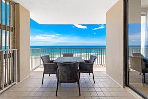 ein Balkon mit Tisch und Stühlen und Blick auf das Meer in der Unterkunft Shoalwater 804 in Orange Beach + 32 Fotos