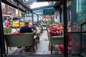 a group of people sitting at tables outside a restaurant at Blue Zerzevan Konak Hotel in Istanbul