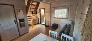 a living room of a wooden cabin with a couch and a table at Domki letniskowe Kika in Sarbinowo