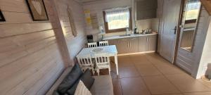 a kitchen with a table and chairs in a room at Domki letniskowe Kika in Sarbinowo +25 photos