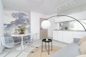 a living room with a table and a kitchen at Apartamenty Lambert Grzybowo in Grzybowo