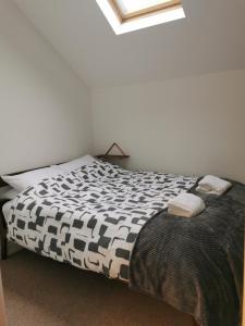 a bedroom with a bed with a black and white comforter at Clock Tower Apartment in Llandrindod Wells