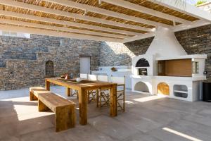 an outdoor patio with a wooden table and a fireplace at Mirabilia, Unique view meets true elegance in Krotiri