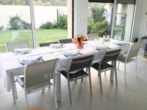 une table à manger avec des chaises et un tissu de table blanc dans l'établissement Lodge Marie, à Villegailhenc