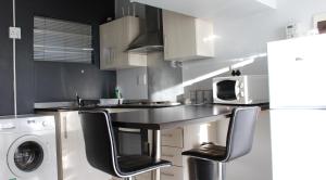 a kitchen with a counter with a washer and dryer at Abigail's Studio Apartment @ Trift Tower in Windhoek