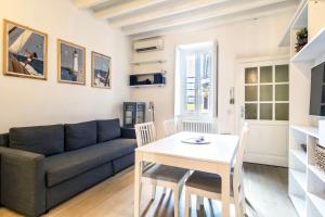 uma sala de estar com um sofá e uma mesa em Lovely apartment on the Navigli river by Easylife em Milão