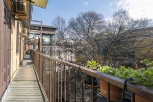uma varanda com um corrimão de madeira e plantas em Lovely apartment on the Navigli river by Easylife em Milão