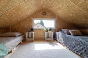 a attic bedroom with two beds and a window at Apartamenty Leśne Zacisze in Lublin