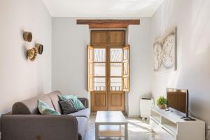 ein Wohnzimmer mit einem Sofa und einem TV in der Unterkunft Macflats Valencia Puerto in Valencia
