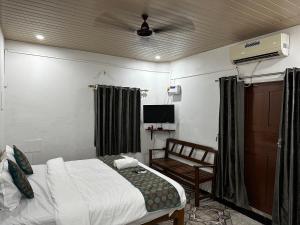a bedroom with a bed and a chair in it at Ocean Way Guest House in Baga