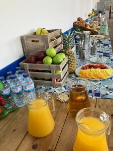 a table topped with glasses of orange juice and fruit at THE FOZ Beach Hotel in Figueira da Foz