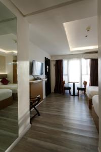 a hotel room with two beds and a living room at Regency Grand Suites in Manila