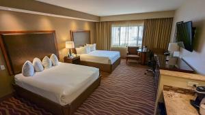 um quarto de hotel com duas camas e uma televisão em Squire Resort at the Grand Canyon, BW Signature Collection em Tusayan