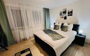 a bedroom with a large bed with white sheets and pillows at 4Rooms Central-Modern near MTU with Balcony, The Beach by Lakescape FeWos in Friedrichshafen