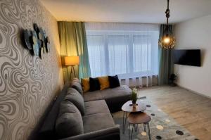 a living room with a couch and a table at 4Rooms Central-Modern near MTU with Balcony, The Beach by Lakescape FeWos in Friedrichshafen