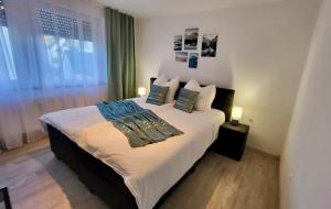 a bedroom with a large bed with two pillows at 4Rooms Central-Modern near MTU with Balcony, The Beach by Lakescape FeWos in Friedrichshafen +3 photos