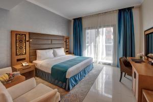 Habitación de hotel con cama y escritorio en Class Hotel Apartments, en Dubái