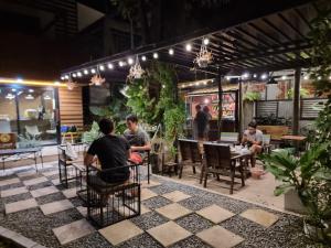a group of people sitting at tables in a patio at Golden House Hotel Sakaeo Room with breakfast in Sa Kaeo