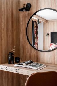 een spiegel bovenop een houten tafel met een boek bij Willa Dunajec - Luxury Apartments in Zakopane