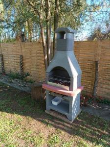 a outdoor oven sitting in a yard next to a fence at Maisonnette en bord de rivière tout près du Mans in La Bazoge