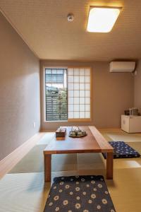 ShimmachidōriにあるKyoto KaedeHotel Kamogawaの木製テーブルと窓が備わる客室です。