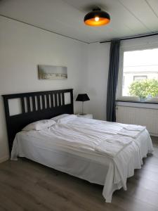Un dormitorio con una gran cama blanca y una ventana en Härlig villa i Sävedalen 10 min till Göteborg en Gotemburgo