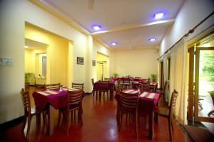 的住宿－Colonial Villa Padukka，餐厅配有桌椅和紫色的桌布