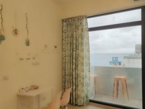 a room with a window with a view of the ocean at Perfect Homestay in Dahan