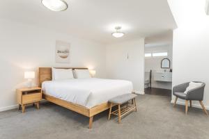 1 dormitorio blanco con 1 cama y 1 silla en Ocean Vista by the BnB Collection en Albany