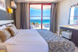 a hotel room with a bed and a view of the ocean at A11 Hotel Obaköy in Alanya