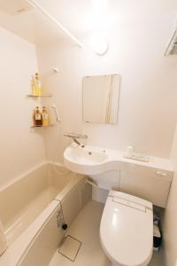 uma casa de banho com um lavatório, um WC e um espelho. em Kyoto KaedeHotel Kamogawa em Shimmachidōri