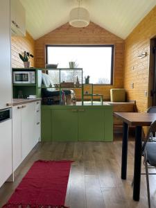 a kitchen with green cabinets and a table at Tiny Heaven Chidea 
