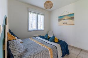 - une chambre avec un lit avec un animal rembourré dans l'établissement Le Grand Barbot - Maison pour 4 proche plage, à Gujan-Mestras