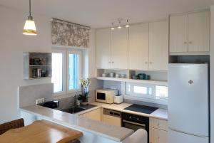 kuchnia z białymi szafkami i białą lodówką w obiekcie Blueberry Villa w mieście Naksos