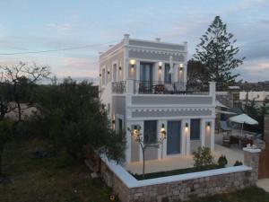 Casa blanca con balcón en la parte superior. en Mavrokastro en Adamas