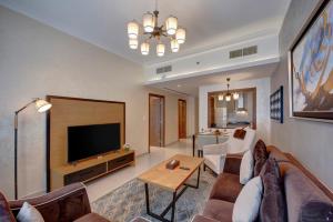 Class Hotel Apartments في دبي: غرفة معيشة بها أريكة وتلفزيون