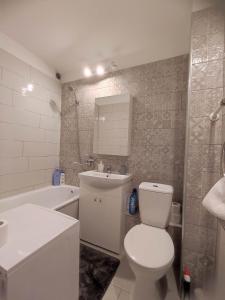 ein Badezimmer mit einem WC, einem Waschbecken und einer Badewanne in der Unterkunft TROFFI T14- SELF CHECK-IN apartment for your comfort in Mažeikiai