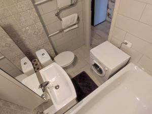 ein weißes Bad mit einem Waschbecken und einem WC in der Unterkunft TROFFI T14- SELF CHECK-IN apartment for your comfort in Mažeikiai